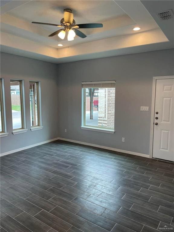 spare room featuring a tray ceiling and ceiling fan