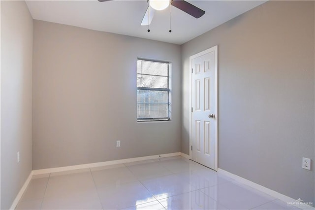 unfurnished room featuring a ceiling fan, baseboards, and light tile patterned floors