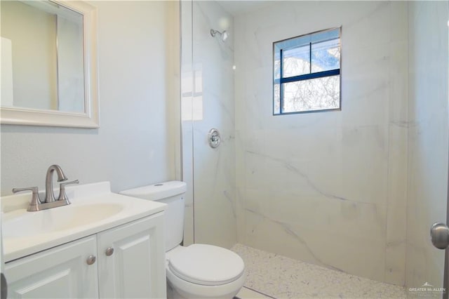 full bath with toilet, vanity, and a marble finish shower