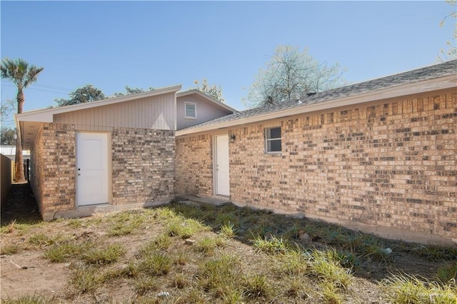 rear view of house featuring brick siding