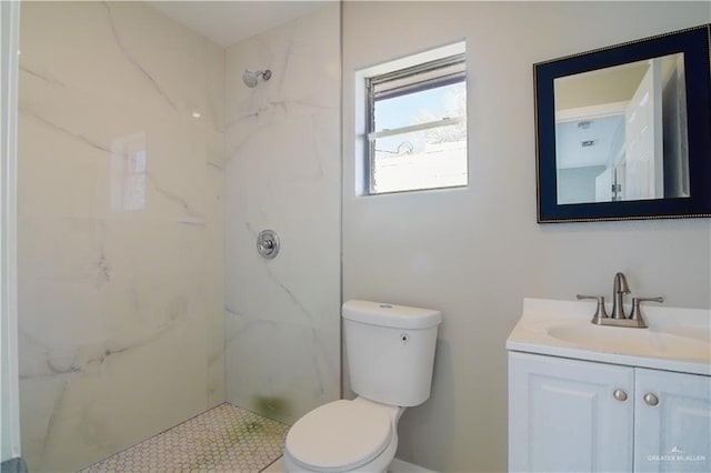 full bathroom featuring toilet, a marble finish shower, and vanity