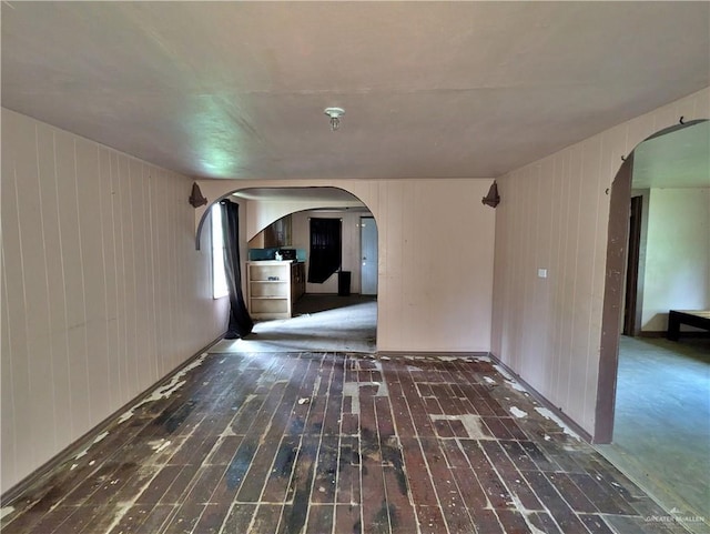 interior space with wooden walls and dark hardwood / wood-style flooring