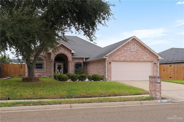 view of front of home with a front yard and a garage