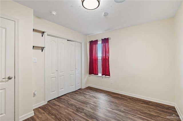 unfurnished bedroom featuring a closet and dark wood-type flooring