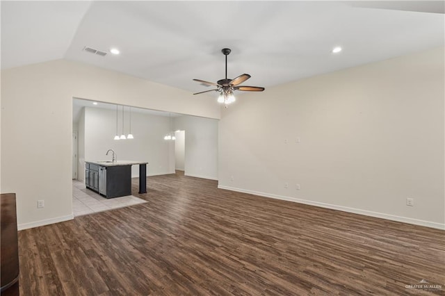 unfurnished living room featuring ceiling fan, lofted ceiling, sink, and light hardwood / wood-style flooring