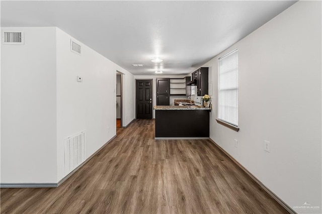 kitchen with dark hardwood / wood-style flooring, white range oven, dark brown cabinetry, and wall chimney range hood