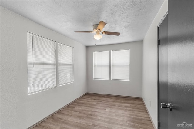 unfurnished room featuring a textured ceiling, light hardwood / wood-style flooring, and ceiling fan