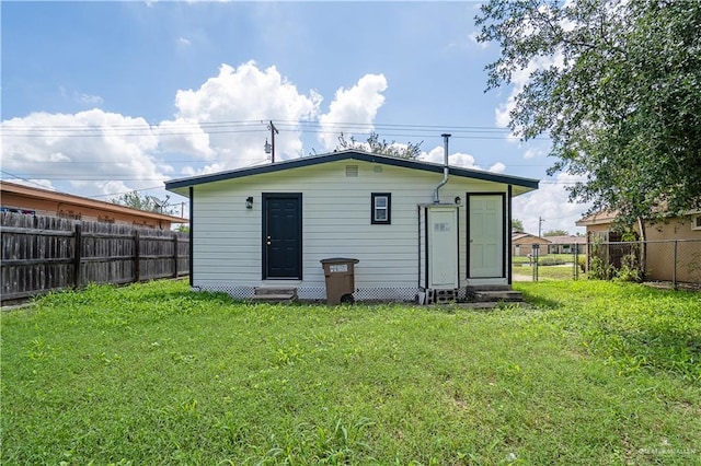 rear view of property featuring a lawn