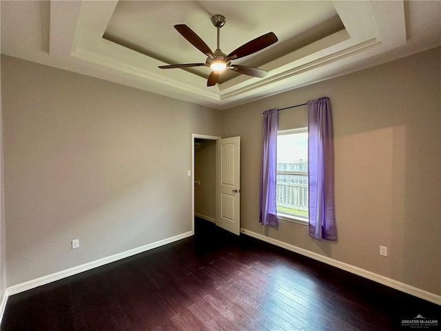2301 Mcleod Ave, Edinburg, TX 78539 - unfurnished room with a tray ceiling, a ceiling fan, and dark wood-type flooring