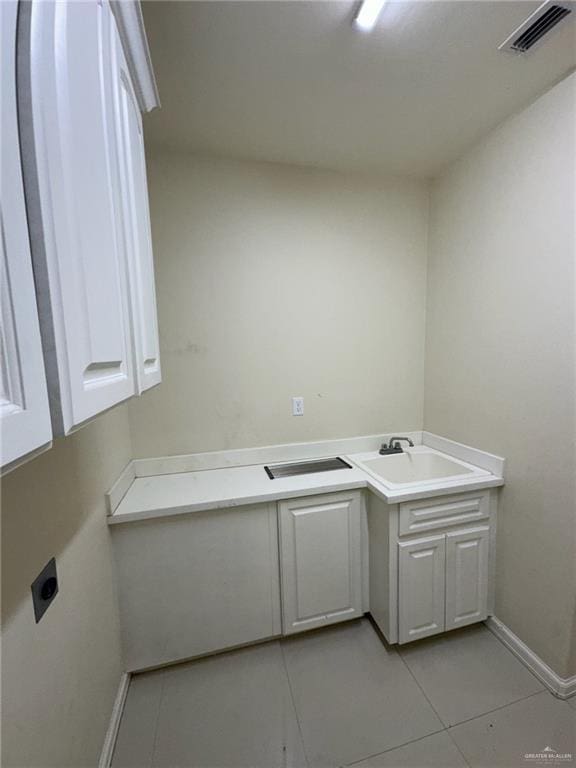 2301 Mcleod Ave, Edinburg, TX 78539 - laundry room with cabinet space and light tile patterned flooring