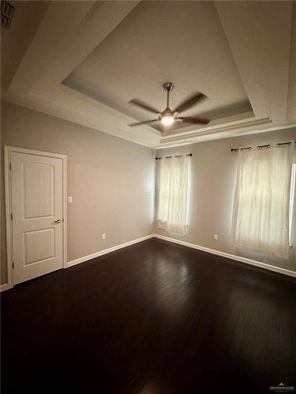 2301 Mcleod Ave, Edinburg, TX 78539 - unfurnished room with a tray ceiling, dark wood-type flooring, and a ceiling fan