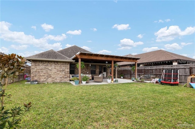 rear view of property featuring a yard, a patio area, and outdoor lounge area