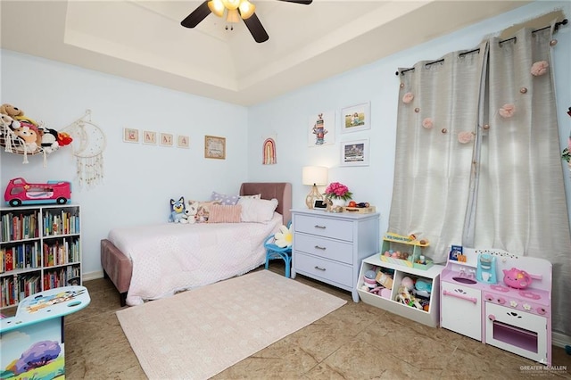 bedroom featuring ceiling fan and a raised ceiling