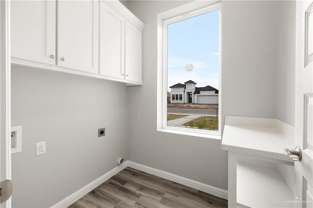 laundry room featuring cabinets, hardwood / wood-style floors, and electric dryer hookup