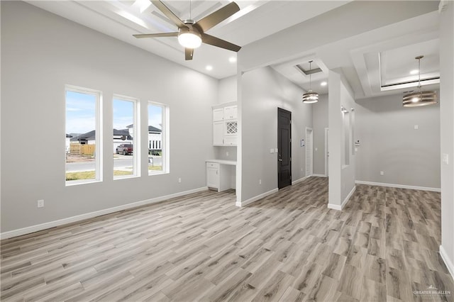 interior space with a towering ceiling, light hardwood / wood-style flooring, and ceiling fan