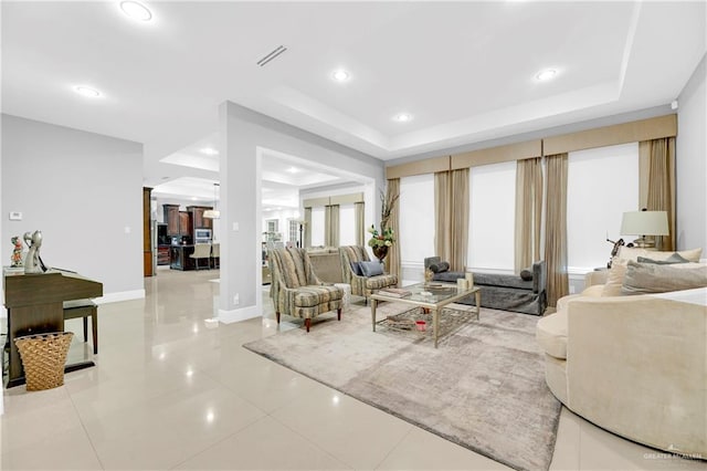 tiled living room featuring a raised ceiling