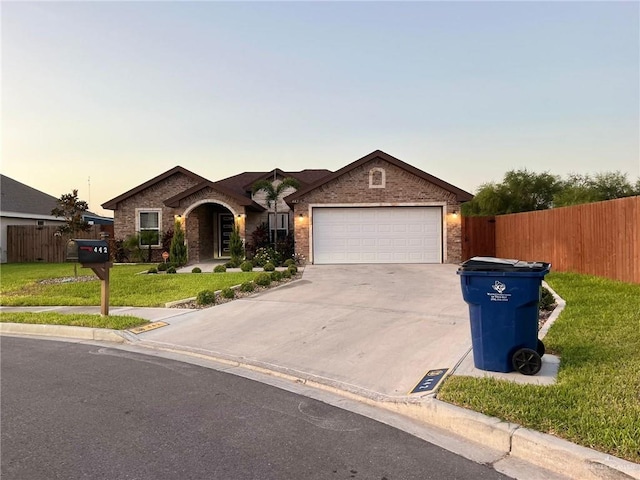 single story home with a garage and a yard