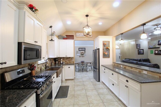 kitchen with stainless steel appliances, white cabinets, a sink, and decorative backsplash