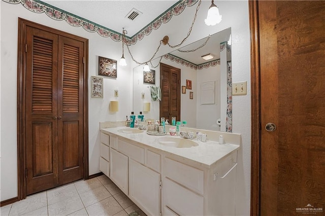 1009 Las Flores Dr, Alamo, TX 78516 - bathroom with a closet, tile patterned flooring, double vanity, and baseboards