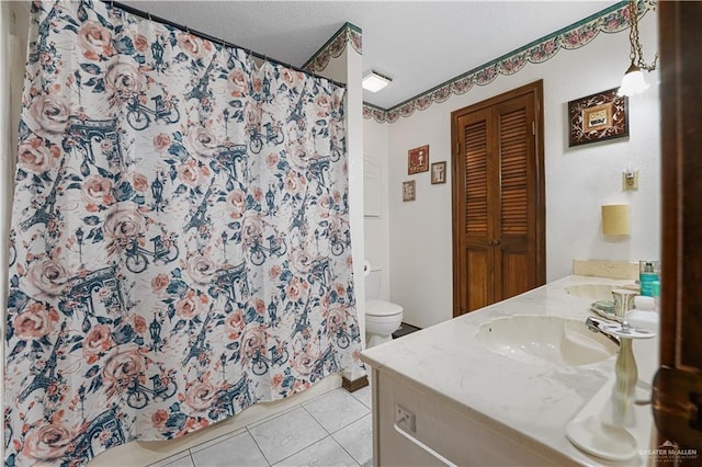 1009 Las Flores Dr, Alamo, TX 78516 - bathroom with double vanity, tile patterned flooring, toilet, a closet, and a shower with shower curtain