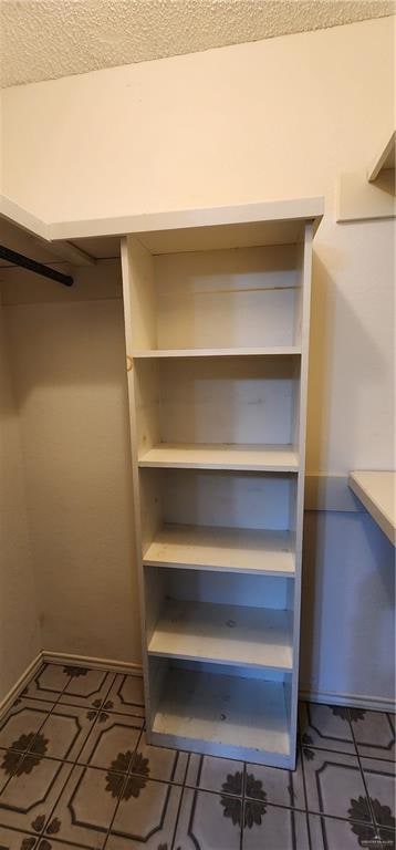 walk in closet featuring dark tile patterned flooring