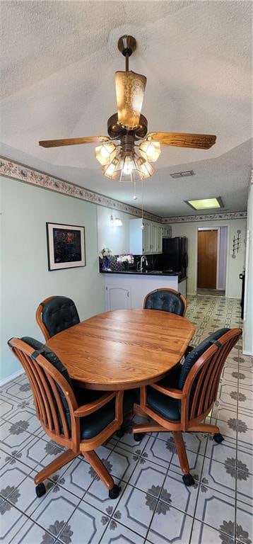 dining room with a textured ceiling, ceiling fan, and sink