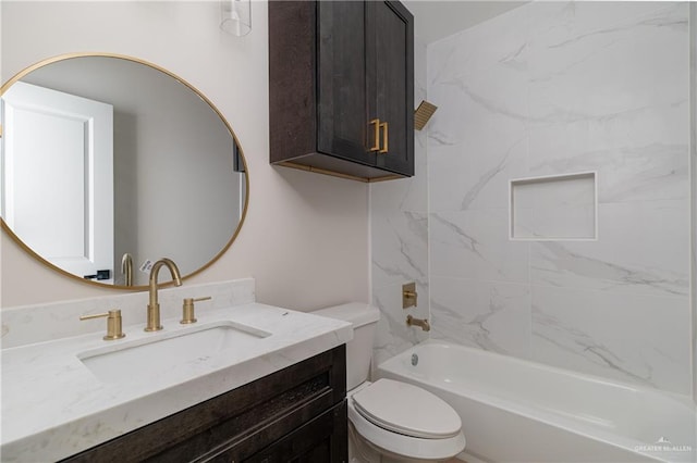 full bathroom featuring vanity, tiled shower / bath, and toilet