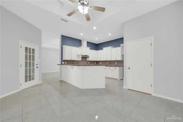 3313 Roadrunner Dr, Edinburg, TX 78541 - kitchen with backsplash, ceiling fan, under cabinet range hood, white cabinetry, and light tile patterned floors