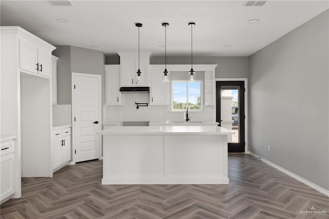 kitchen featuring white cabinetry, a center island, light parquet floors, and hanging light fixtures