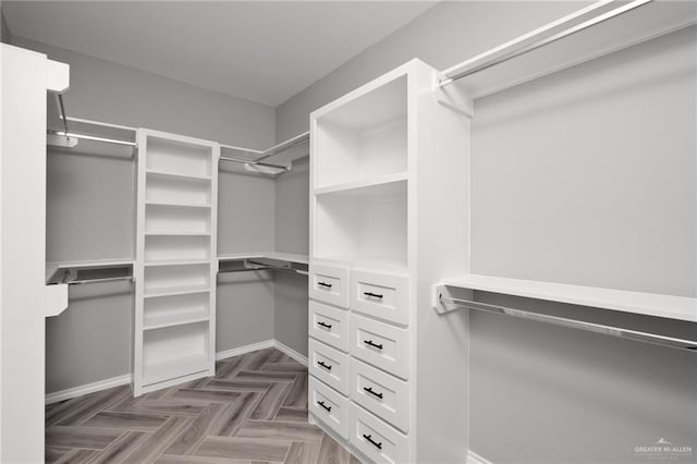 spacious closet with dark parquet floors