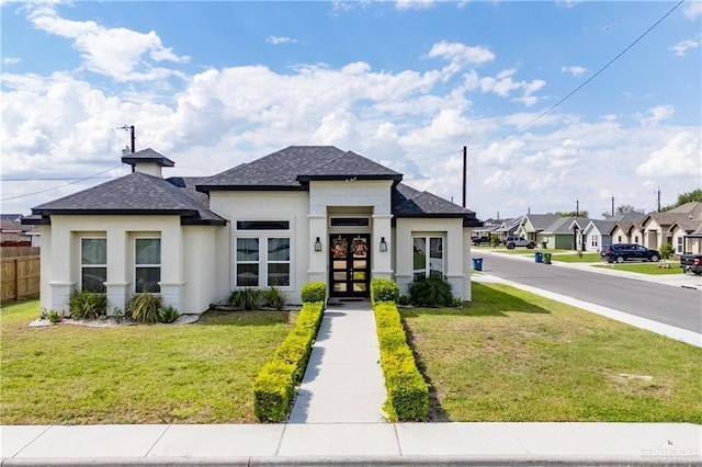 prairie-style house with a front yard, fence, roof with shingles, stucco siding, and french doors