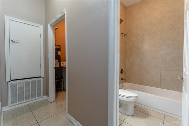 bathroom with shower / tub combination, toilet, tile patterned flooring, visible vents, and baseboards