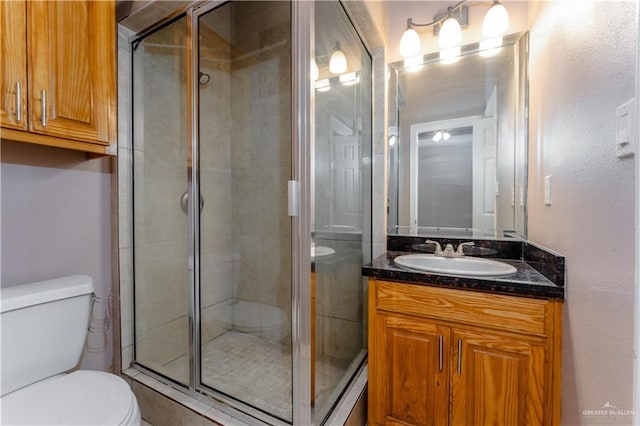 bathroom featuring a stall shower, vanity, and toilet