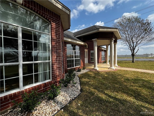 entrance to property with a lawn and a porch