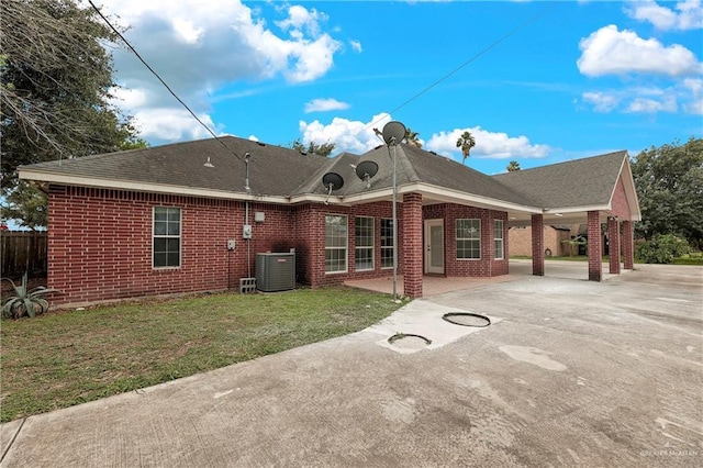 rear view of property featuring a yard and central AC unit