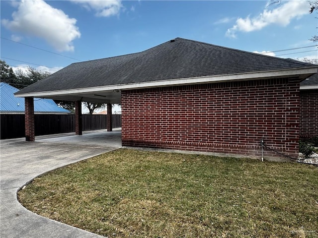 view of side of home featuring a lawn and a carport