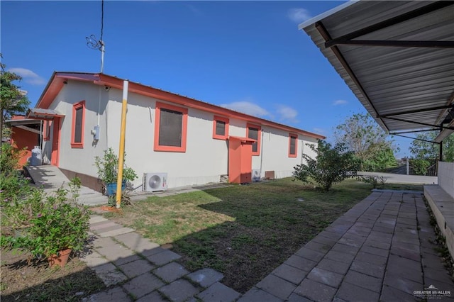 back of house with a yard and ac unit