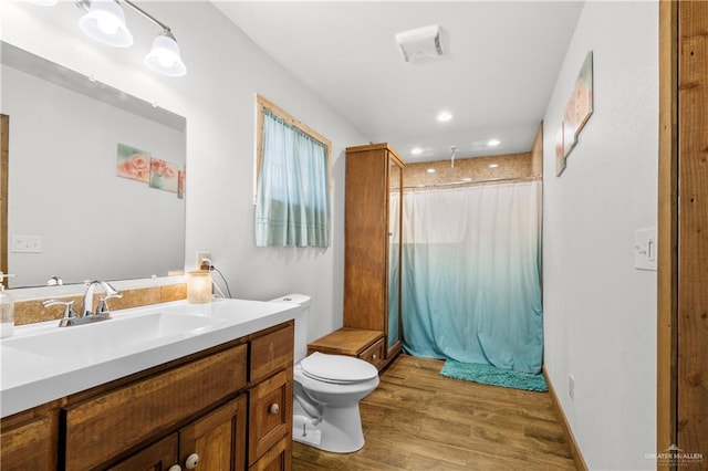 bathroom with vanity, curtained shower, toilet, and wood-type flooring