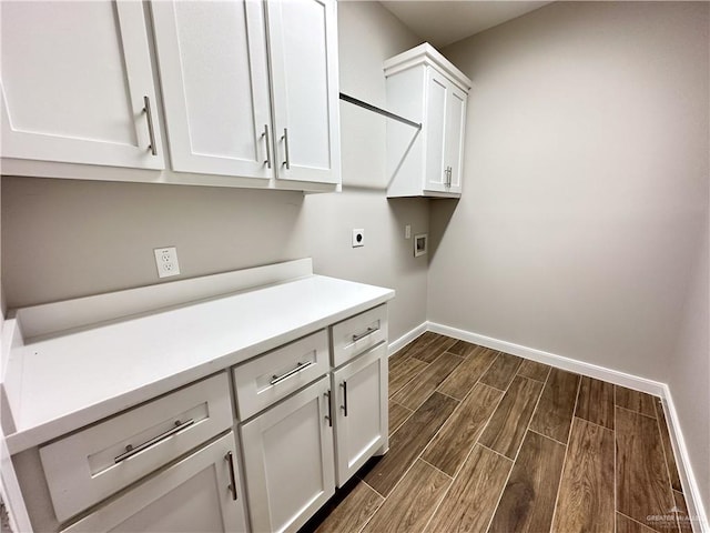 clothes washing area with electric dryer hookup, hookup for a washing machine, dark hardwood / wood-style flooring, and cabinets