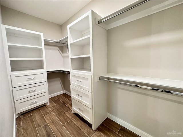 walk in closet with dark wood-type flooring