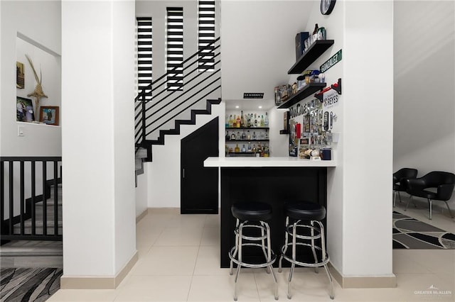 1820 Hill Dr, Mission, TX 78572 - indoor dry bar featuring stairway, light tile patterned flooring, and baseboards
