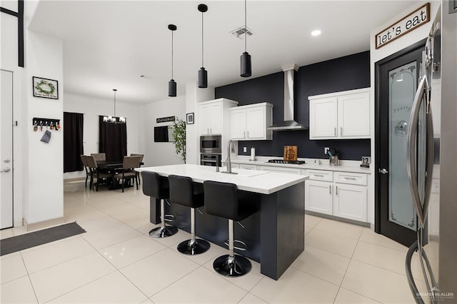 1820 Hill Dr, Mission, TX 78572 - kitchen with wall chimney exhaust hood, appliances with stainless steel finishes, light countertops, a kitchen bar, and white cabinets