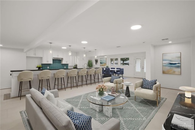 living area with recessed lighting, beam ceiling, visible vents, and baseboards