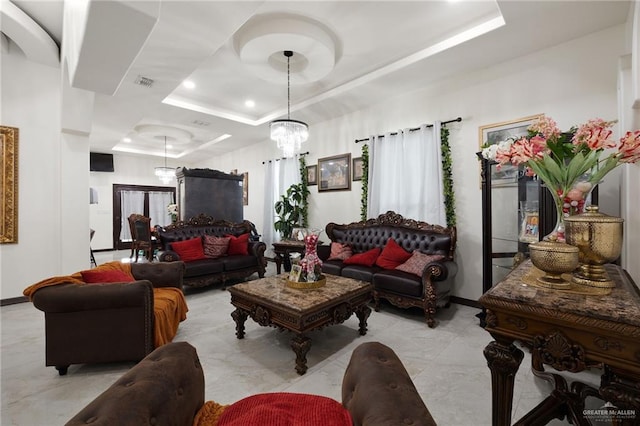 living room with a tray ceiling and a notable chandelier