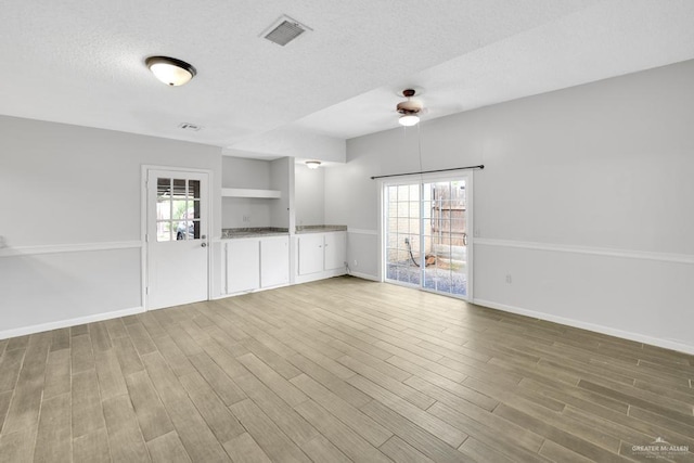 704 Kerry Ln, Mcallen, TX 78504 - unfurnished room with a textured ceiling, healthy amount of natural light, a ceiling fan, wood finished floors, and baseboards