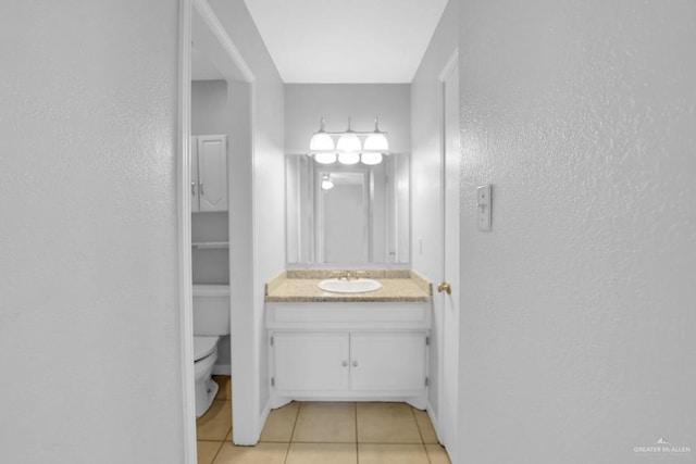 704 Kerry Ln, Mcallen, TX 78504 - bathroom featuring tile patterned floors, a textured wall, vanity, toilet, and baseboards