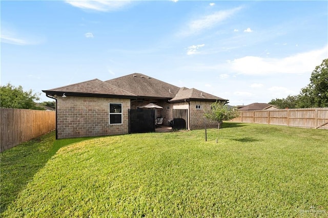 201 White Oak Dr, Los Fresnos, TX 78566 - rear view of property featuring a fenced backyard, brick siding, and a shingled roof