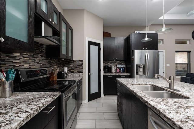 201 White Oak Dr, Los Fresnos, TX 78566 - kitchen with appliances with stainless steel finishes, backsplash, pendant lighting, dark cabinets, and glass insert cabinets