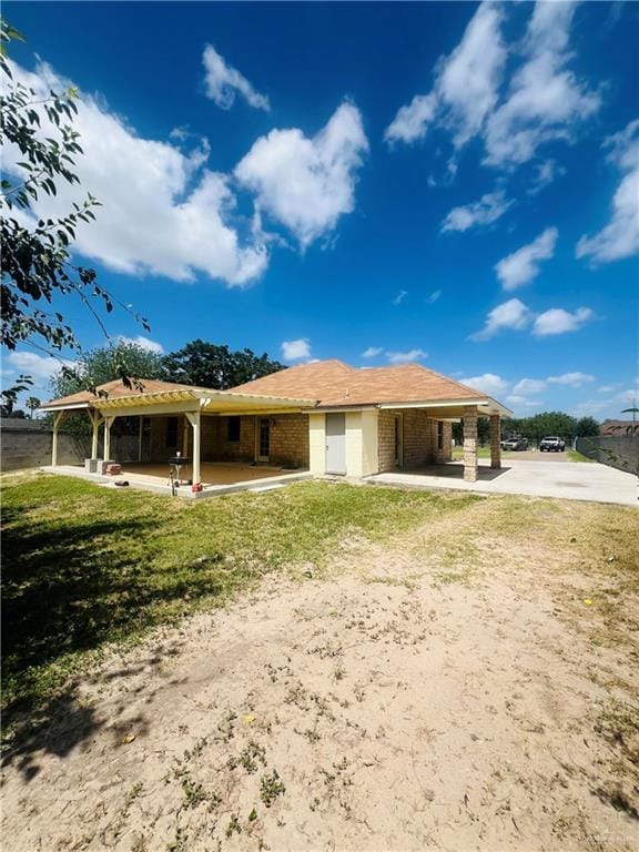 8200 Tierra Linda Ln, Mission, TX 78574 - rear view of property with driveway, an attached carport, brick siding, and a lawn