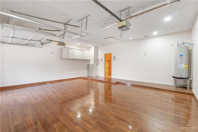 garage featuring baseboards, electric water heater, and a garage door opener